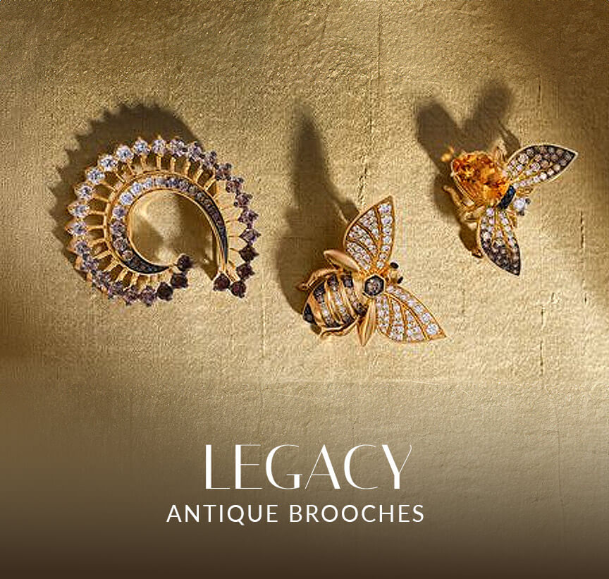 Le Vian® antique-inspired brooches with diamond accents and nature motifs displayed on textured gold fabric.