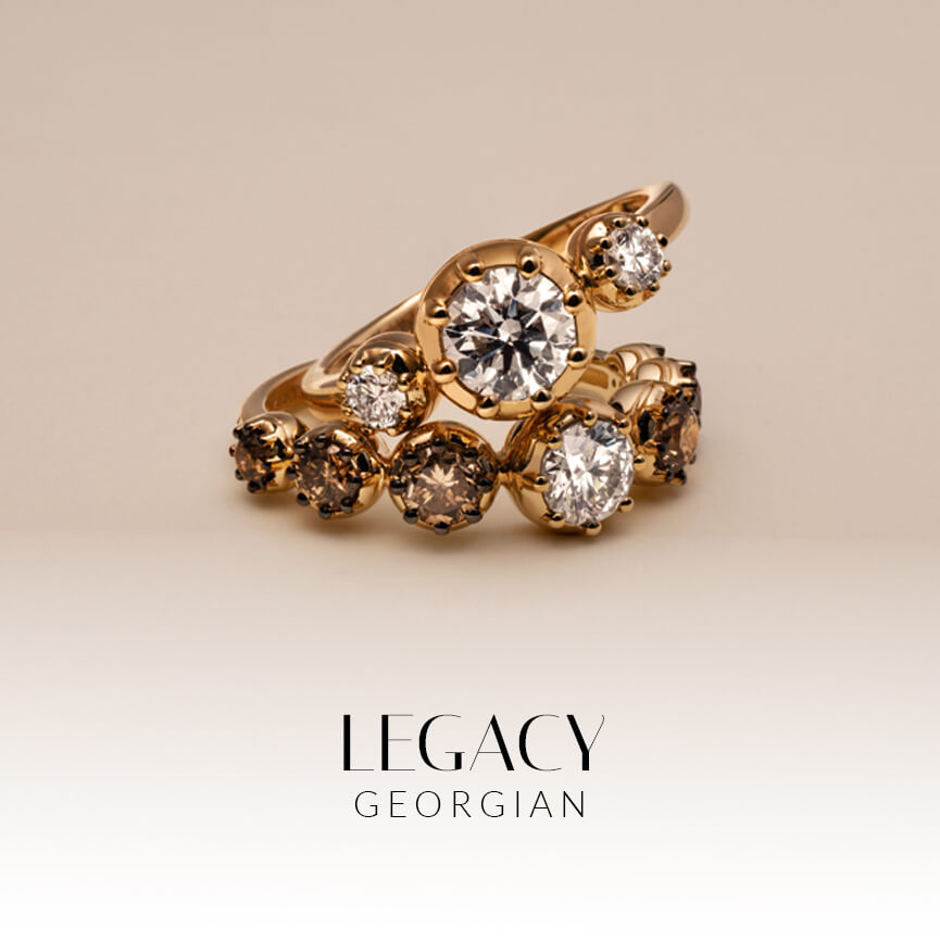 Two Georgian era vintage inspired gold rings stacked with nude and chocolate brown diamonds on a beige background.